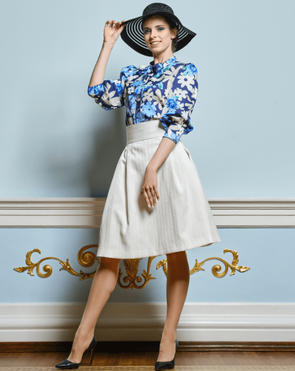 A stylish individual standing indoors in an elegant setting, wearing a wide‑brimmed hat, floral blouse, and white skirt, conveying sophistication and high‑end lifestyle. 🏷️ Caption Tailored protection for those who live life with distinction. 📄 Long Description The image features a fashionably dressed individual posing in an elegant interior with soft blue walls and ornate gold detailing. Their wide‑brimmed hat, floral blouse with structured sleeves, and high‑waisted white skirt create a refined, high‑fashion look. The poised stance and polished styling evoke exclusivity, confidence, and a lifestyle defined by elevated choices. This visual supports the High Net Worth Individuals offering — bespoke insurance solutions designed for clients who expect exceptional service and premium protection. 🔖 Image Title Elegant portrait representing luxury lifestyle If you want, I can also help you create a unified luxury tone across all HNWI images or craft a headline and subheading for the entire section.