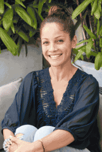 A smiling customer sitting outdoors in a relaxed setting, surrounded by greenery, conveying warmth and trust.