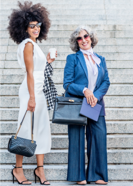 Two stylish women standing outdoors on stone steps, representing confidence, mobility, and a modern nomadic lifestyle.
